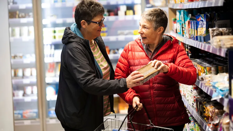 Zwei ältere Menschen kaufen gemeinsam im Supermarkt ein